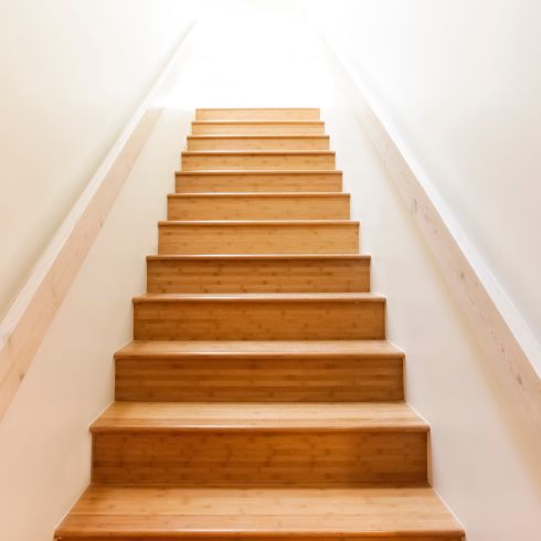 Wood steps leading upstairs with white walls