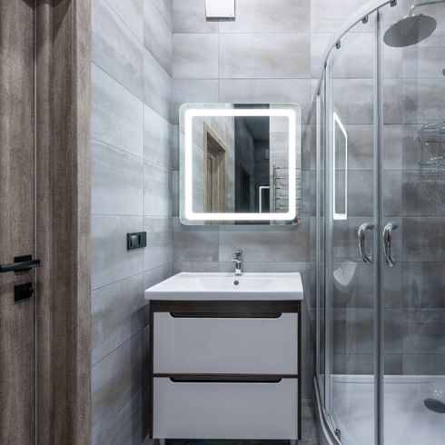 Bathroom with gray tiles, a shower and medicine cabinet