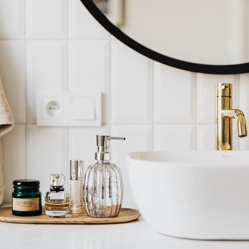 Bathroom sink with accessories and a circle mirror