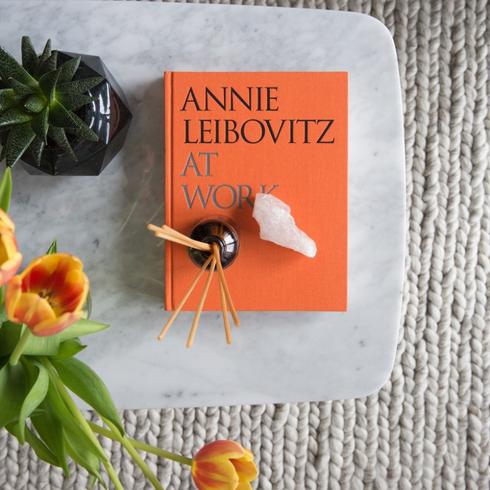 Clean coffee table with an orange book and flowers