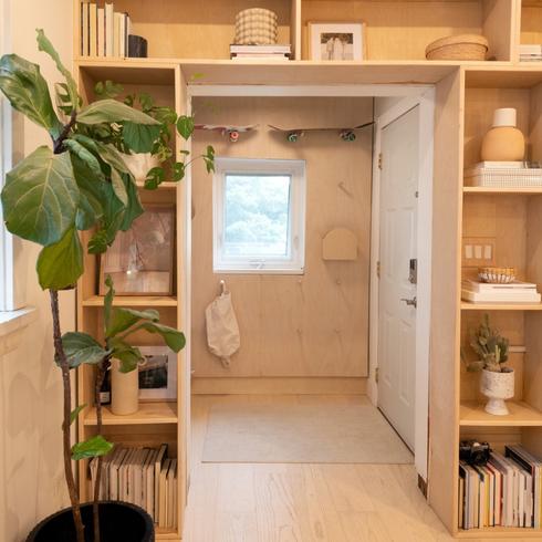 Entryway with built-in shelves and a plant
