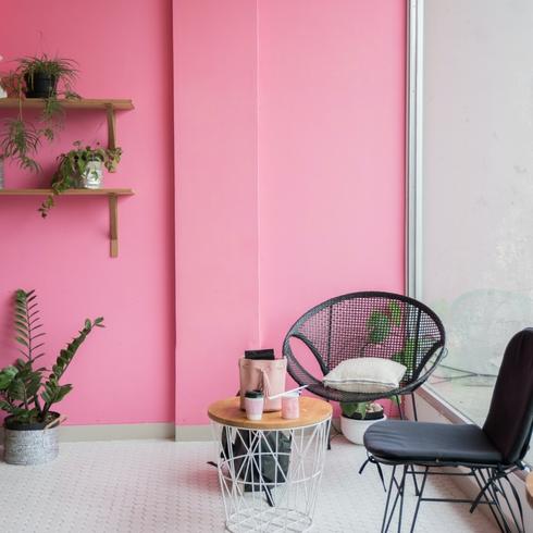 Bright pink room with black chairs