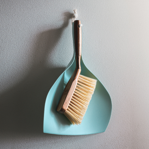 A small hand broom and dustpan