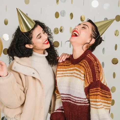 Two friends laughing at a holiday party