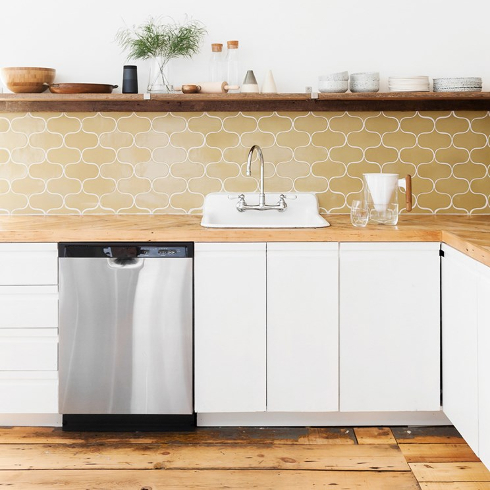 A stainless steel dishwasher in a wood-themed kitchen