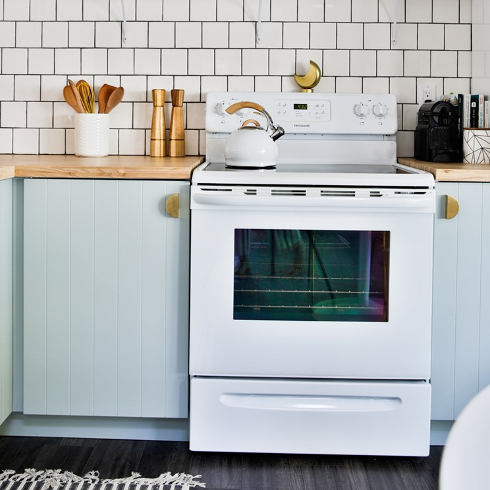 Beautiful kitchen renovation with white stove and subway tile backsplash