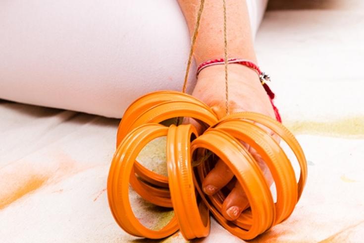 Tiffany Pratt tying orange Mason jar lids together