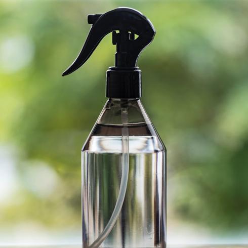 a spray bottle full of vinegar by a window