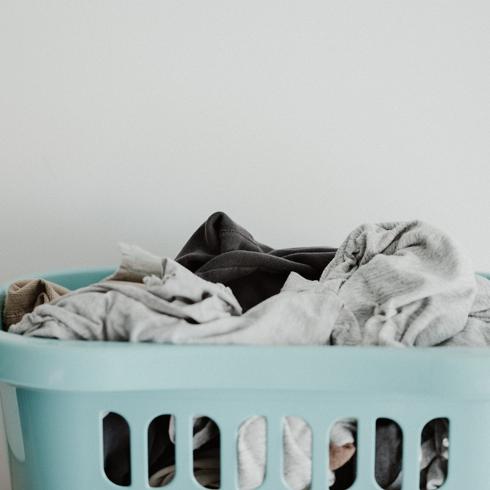 a blue laundry basket filled with laundry
