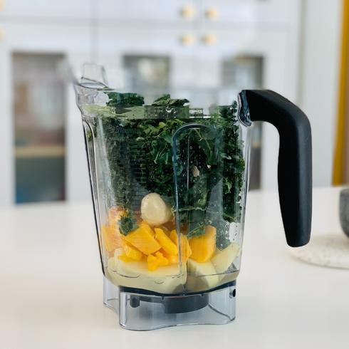 a blender full of spinach and fruit