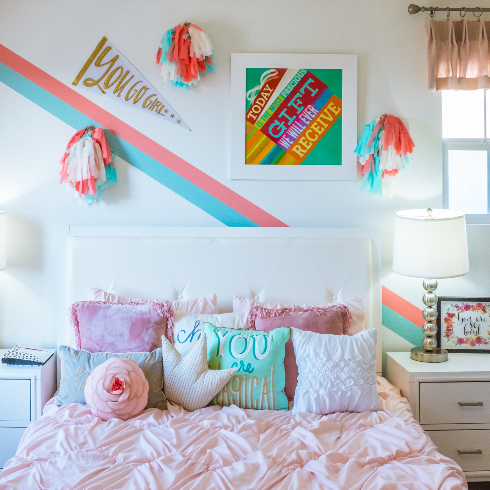 A kids room with gallery wall and textured pink bedspread