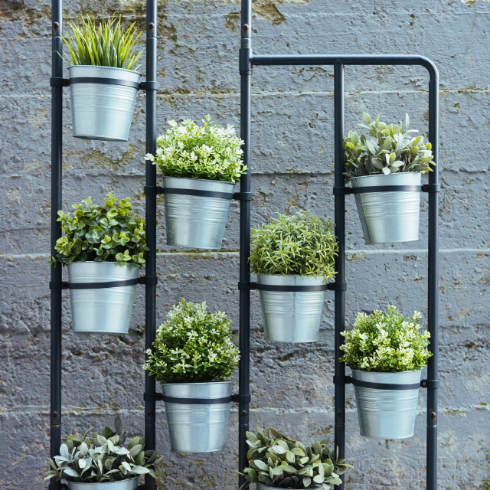 A vertical planter with green plants in a silver pot