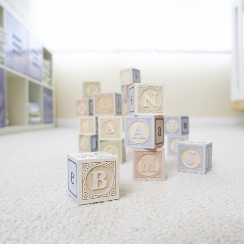Wooden blocks on a white carpet in a baby's room