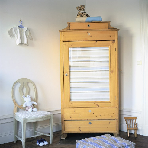 Large wooden wardrobe in a baby nursery room