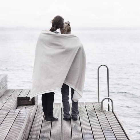 Two women stand on dock with blanket