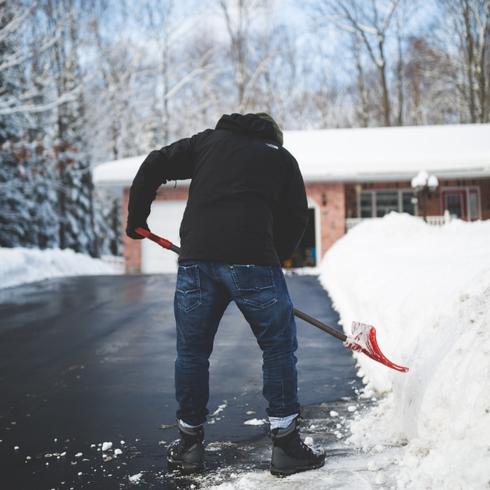 Man shoveling snow on a driveway
