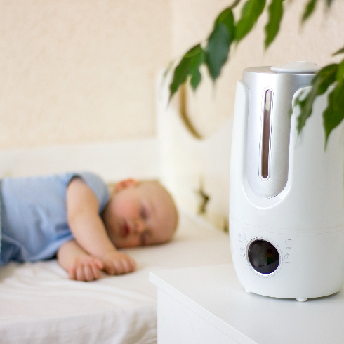 Cute little baby boy sleeping in bedroom with air humidifier. - stock photo