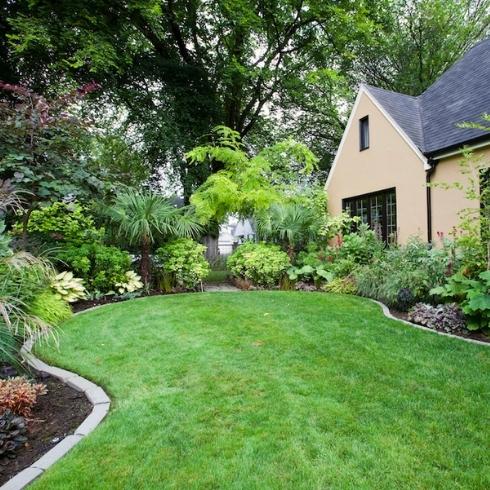 landscaped yard with garden edging and green lawn