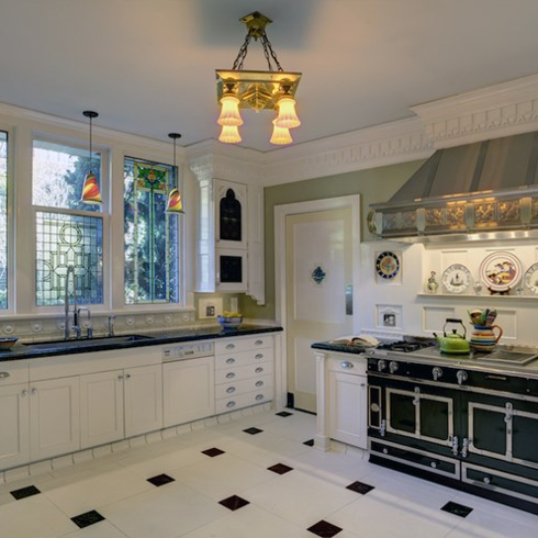 green and white kitchen with stained glass windows and metallic oven