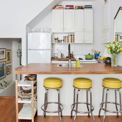 White kitchen with food countertop and yellow stools