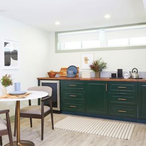 small kitchen area with forest-green lower cabinets and partial backsplash