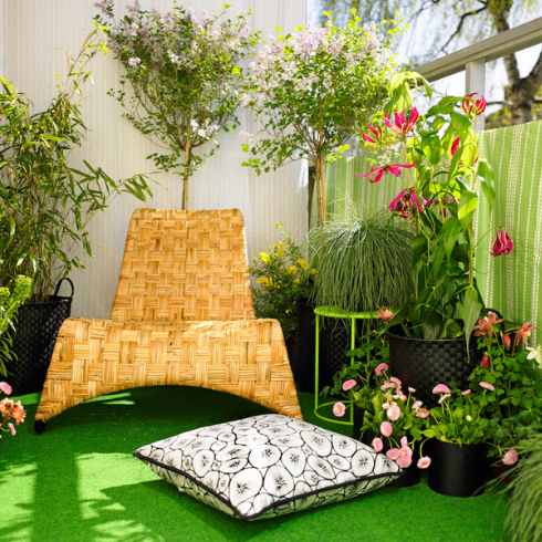 A green balcony with a rattan lounger