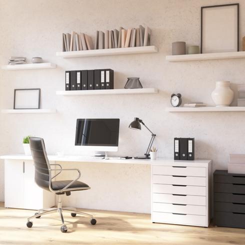 Home office with a chair, desk, and white shelves