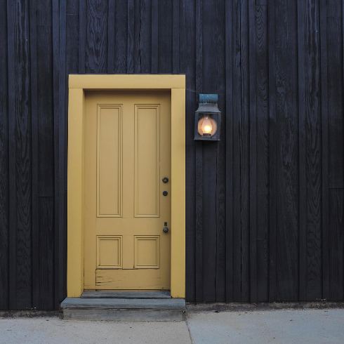 A modern front door facade with yellow painted door
