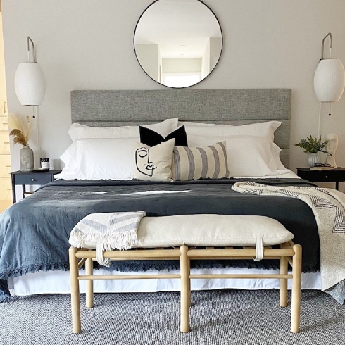 grey bed with pillows arranged at headboard