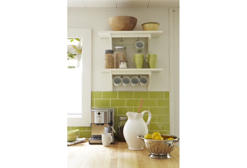 Lime green subway backsplash and bright decorative pitchers in a cottage kitchen