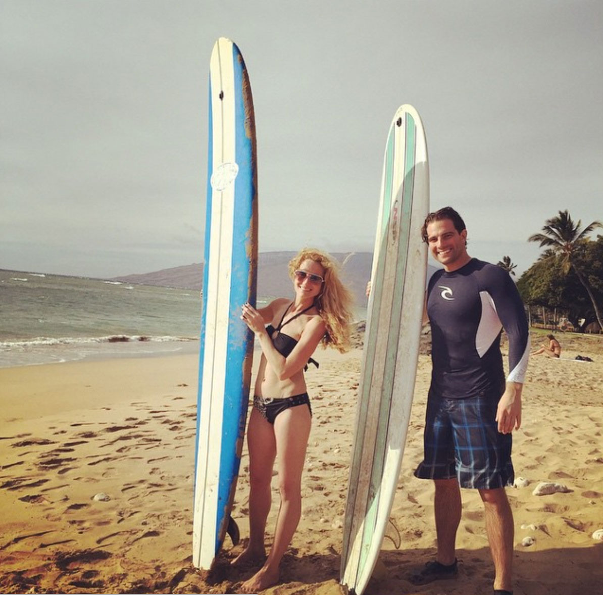 Sabrina and Scott McGillivray surfing at the beach