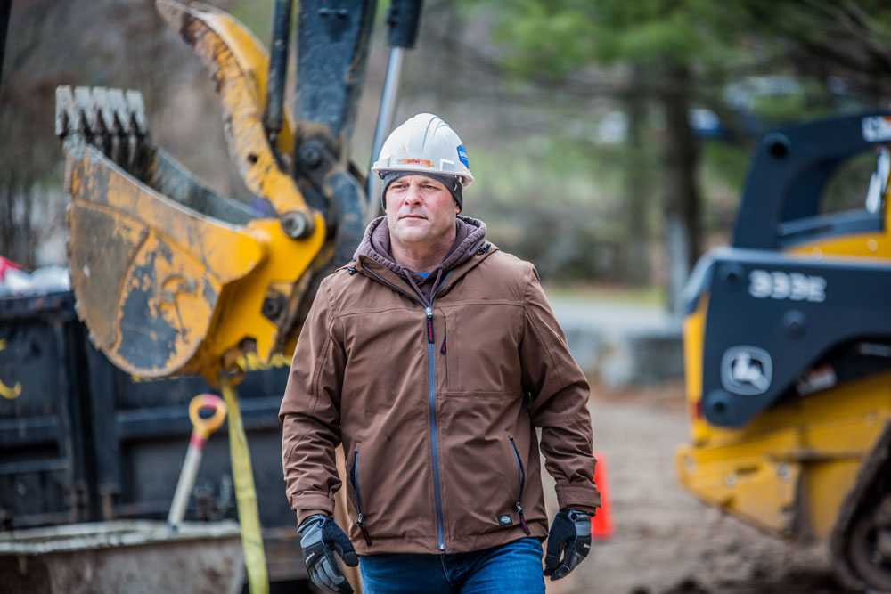 Bryan Baeumler on construction site with bulldozers in the background.