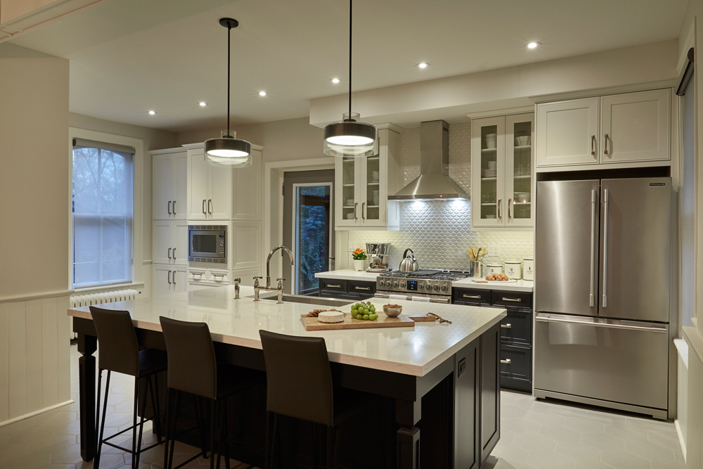 Modern white kitchen with large island and textured backsplash.