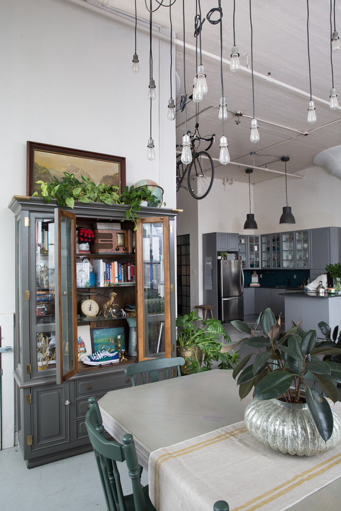 Large loft with dining area, grey cabinetry and tons of greenery