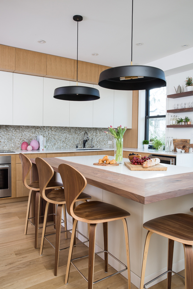 Kitchen and island from corner angle with two black pendant lights above