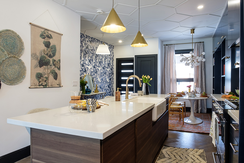 Mid century modern style kitchen with large centre island, white countertops and two gold pendant lamps