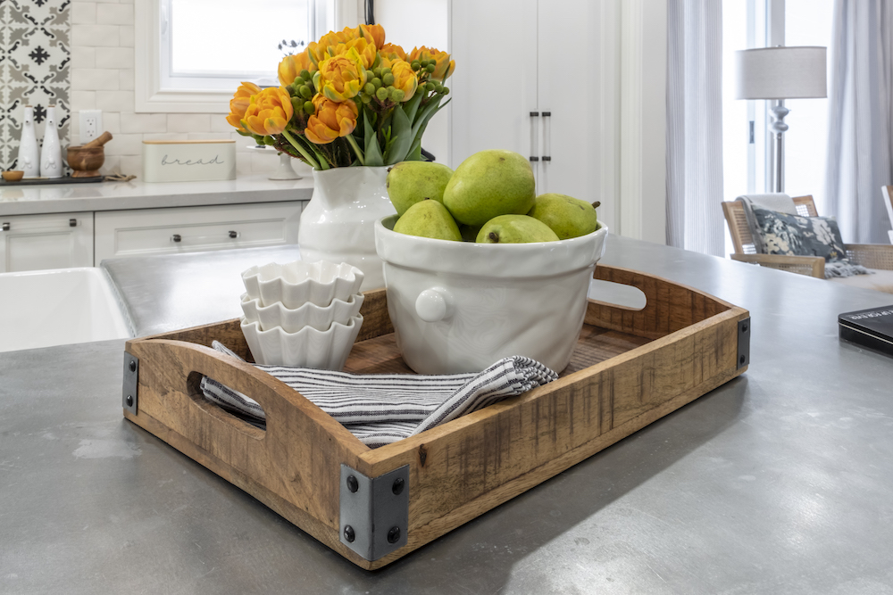 Wooden tray with a bowl of pears sits on a zinc counter in a chic French inspired kitchen