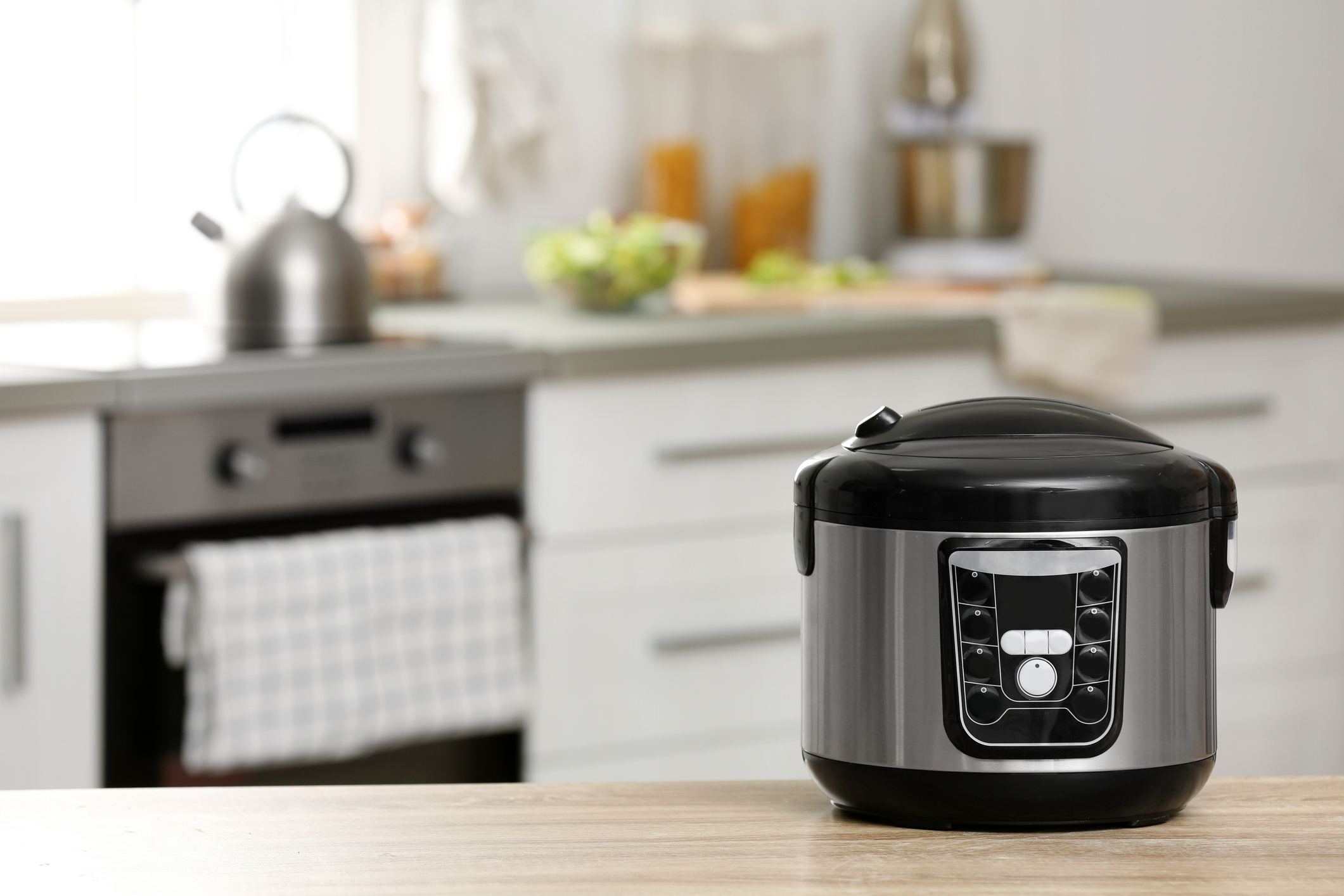 Modern electric multi cooker on table in kitchen