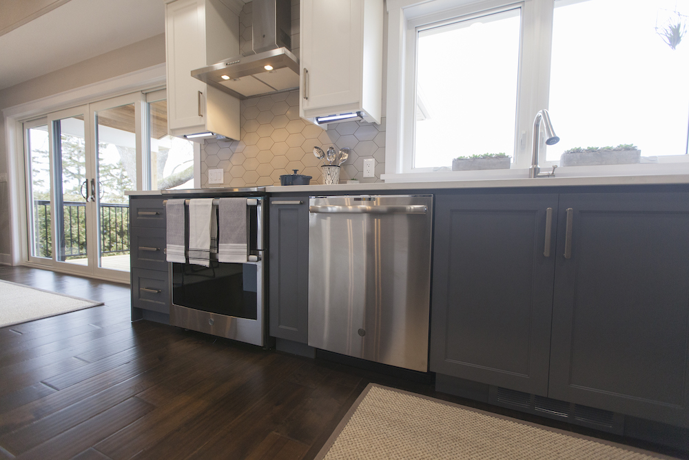 Modern kitchen with dark wood floors, muted blue cabinets and stainless steel appliances