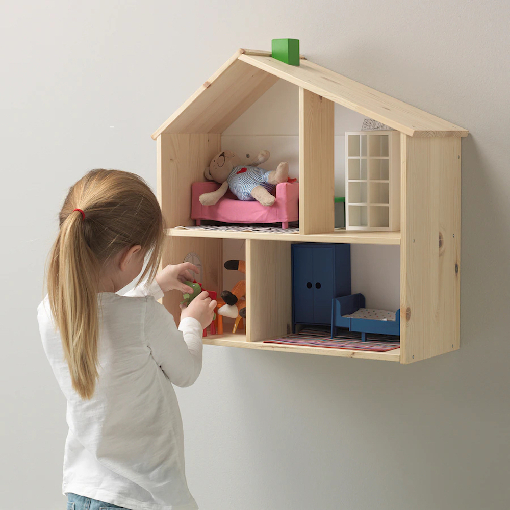 Flisat wooden doll house and shelf from Ikea with a little girl playing with toy furnishings