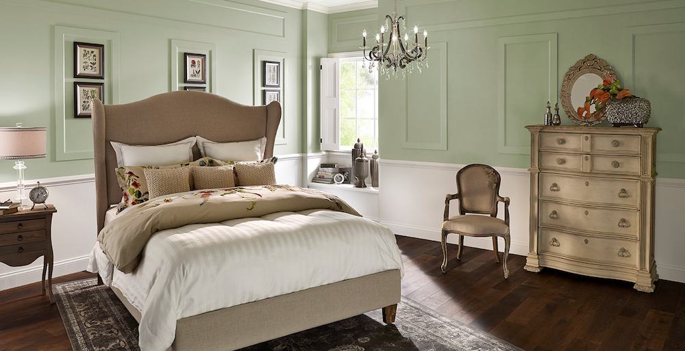 classic bedroom with green and white walls and ornate chandelier