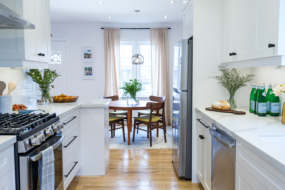 White modern kitchen with quartz countertops and light oak flooring