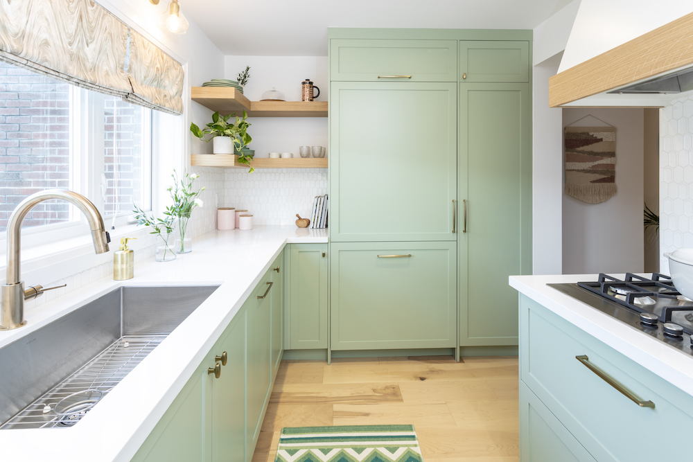 Beautiful new kitchen with wide maple floors, a deep sink, white countertops, sage green cabinets and floating wooden shelves