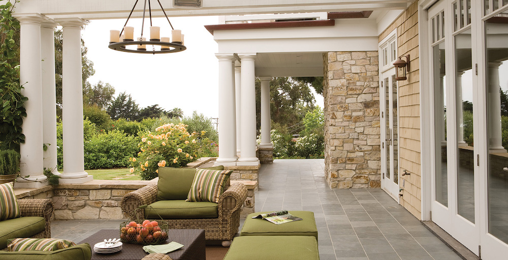 outdoor living room with green furniture and outdoor hanging light fixture