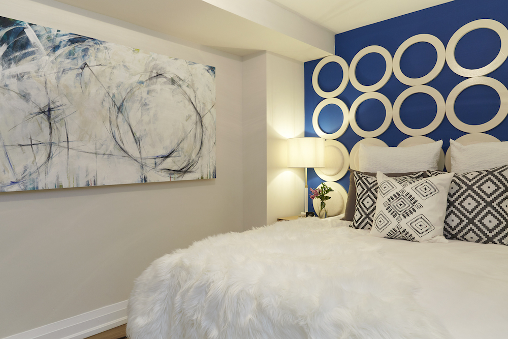 Buyers Bootcamp abandoned bungalow basement apartment main bedroom blue and white wall art feature and faux fur bedspread