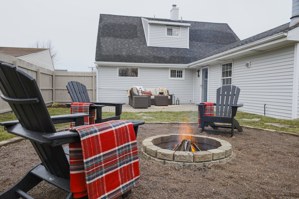 Buyers Bootcamp Cape Cod backyard firepit with black Adirondack chairs