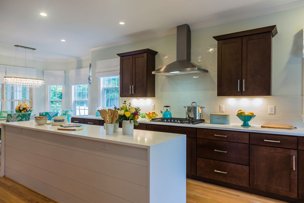 Spacious kitchen with extra-long island clad in clapboard.