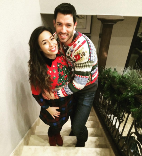 Drew Scott and Linda Phan posing together, wearing holiday sweaters.