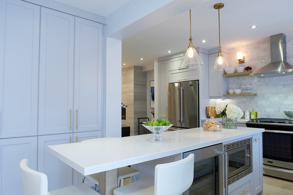 A chic white kitchen with floor to ceiling cabinets and a long white centre island