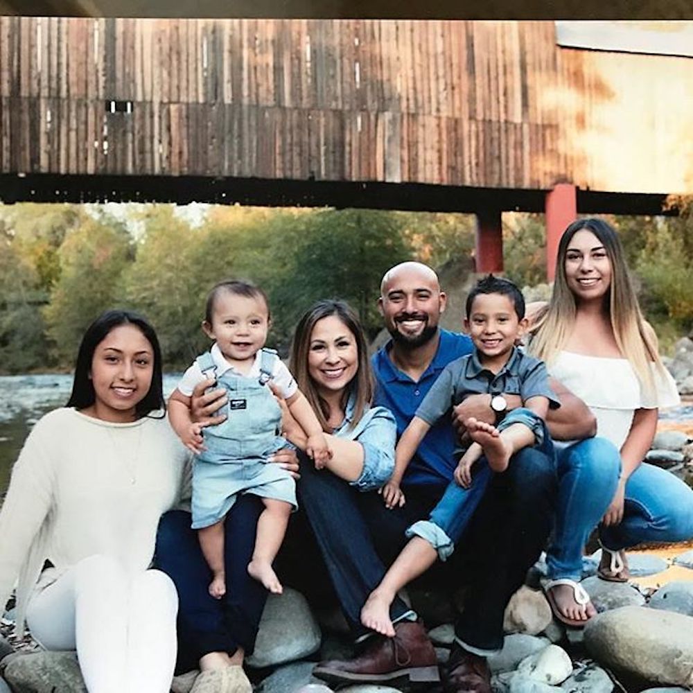 Rustic Rehab hosts Chenoa and David Rivera pose with their family under a bridge